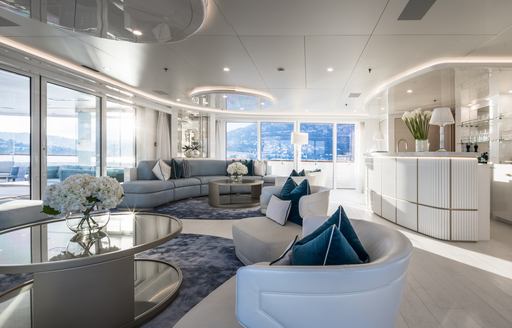 Interiors onboard charter yacht CORAL OCEAN, bar to starboard with two seating areas, surrounded by large full height windows