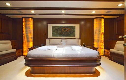 large bed and amber pillars in the master suite aboard sailing yacht Aria I 