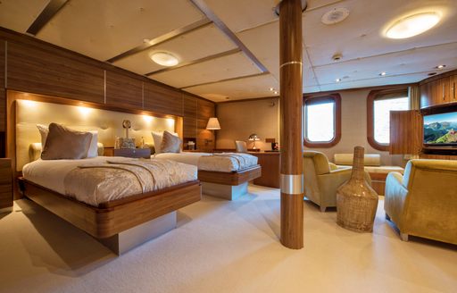Twin beds in a cabin on board superyacht Sherakhan, with armchairs facing the windows
