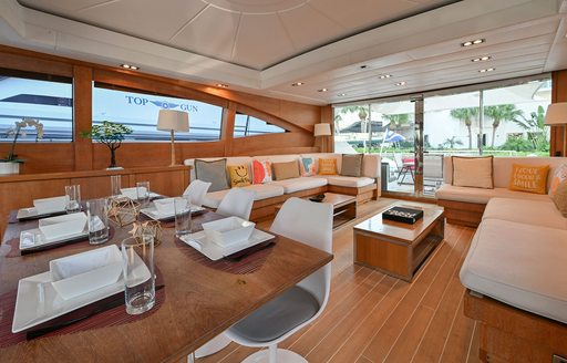 Main salon onboard charter yacht SMILE, dining area in the foreground with a spacious lounge in the background