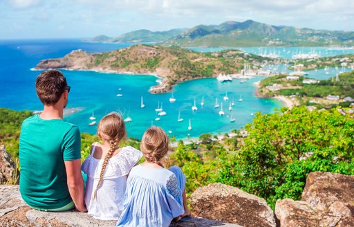 Family on hill looking over Virgin Islands bay and charter yachts