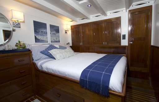 bed and rich wooden joinery in the master suite of sailing yacht EROS