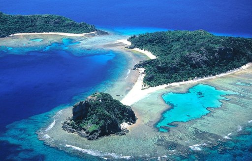 aerial views of islands in Fiji with turquoise waters and white sandy beaches