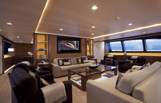 Main salon on sailing yacht Fidelis, with sofas facing a TV and windows
