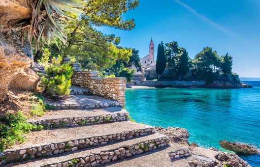 Croatia island with steps and a church and pine trees in the background