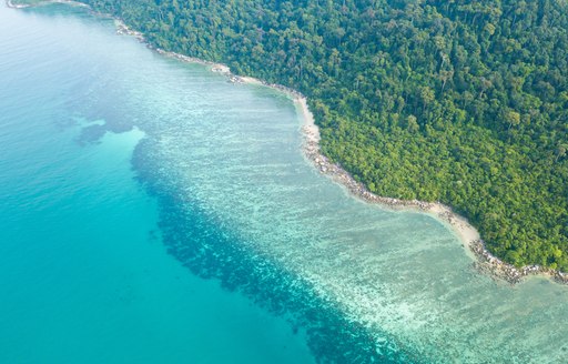 Aerial view of Beautiful coral reef along the tropical island coast with emerald clear water, part of Great Barrier Reef