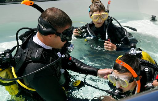 Yacht crew help guests with their scuba gear on board charter yacht ROMA