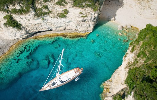 A sailing yacht anchored in a Mediterranean cove