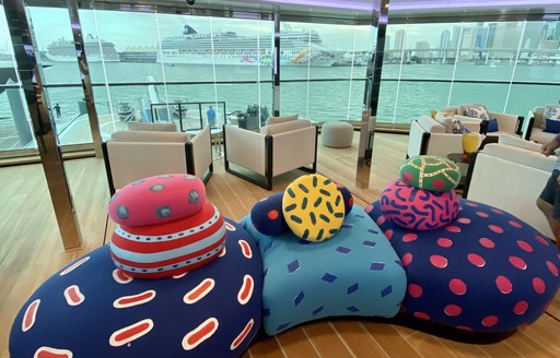 the colourful and comfortable seating inside superyacht BOLD upper deck overlooking the docks of the miami yacht show 2020 in florida