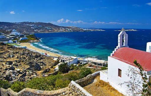 view of beautiful white sand beach from hilltop with a red-roofed church