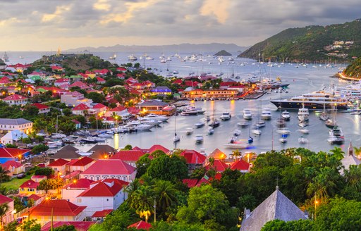 Elevated view of Gustavia Harbor at dusk with motor yacht charters berthed