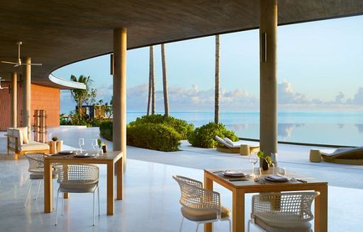 Tables overlooking the turquoise waters of Maldives at the Miera Eau bar in the Ritz-Carlton resort