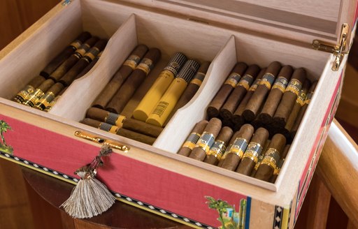 detail shot of box of vintage cigars on board luxury charter yacht over the rainbow's main salon