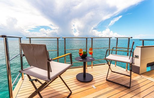 Charter yacht CIELO NERO exterior deck space with chairs by water's edge