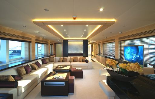 Main salon onboard charter yacht TATIANA I, spacious lounge area with white plush seats surrounded by wide windows