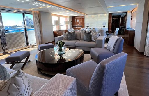 Overview of the main salon onboard charter yacht LE VERSEAU, spacious lounge area with plush sofas and armchairs in the foreground