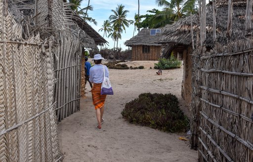 woman walks though fishing village on remote island in tanzania