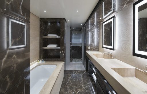 Looking into marble en-suite bathroom on superyacht SEVERIN'S with bath to the left and sinks to the right
