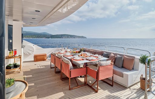 Main deck aft onboard charter yacht MAKANI II, alfresco diniing option with long sofa and adjacent dining table