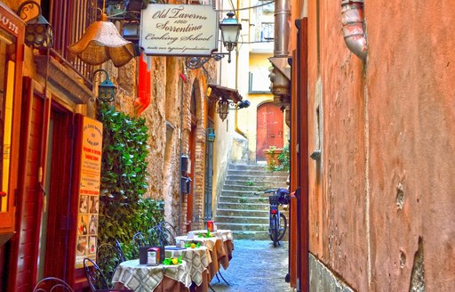 Narrow alley with old buildings and chairs set out