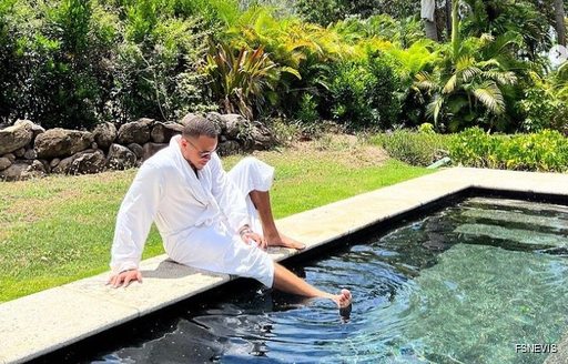 Man dipping his foot in a spa pool at the Four Seasons in Nevis