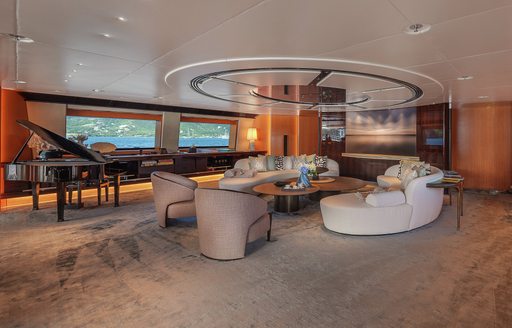 Interior seating area with a grand piano onboard sailing yacht charter MALTESE FALCON