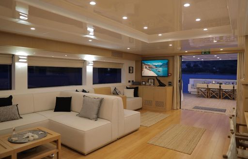 View across interior on Superyacht Ottawa IV with large flat screen TV and door leading outside visible