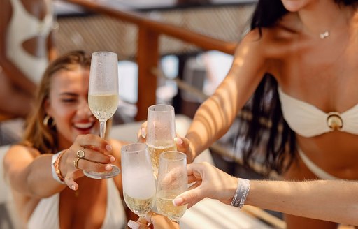 Charter guests at YONA Beach Club toasting champagne
