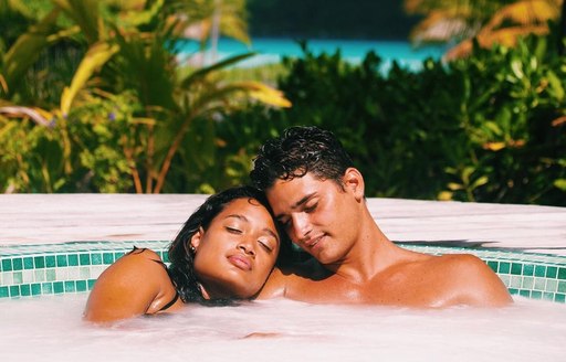 Two couples relaxing with their heads resting on each other in a jacuzzi in the Deep ocean Spa Bora Bora