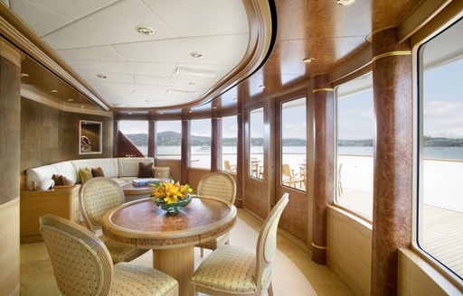 Traditionally styled chairs surround a table situated in the interior of a superyacht