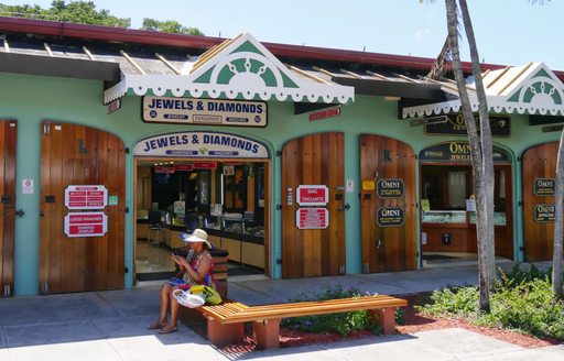  A woman sits outside the jewelry stores at the duty free shopping center outside the cruise ship terminal in St. Thomas, US Virgin Islands.