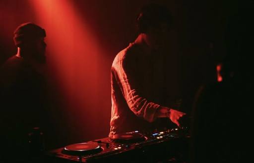 DJ in darkness with red light
