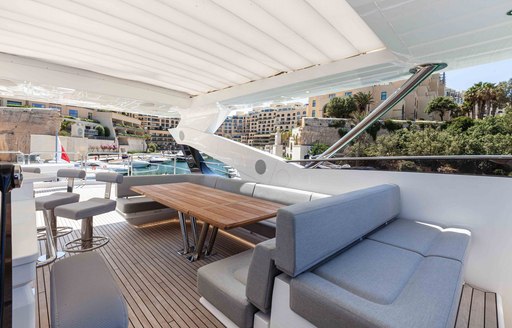 Exterior dining and lounge area onboard charter yacht NEW EDGE