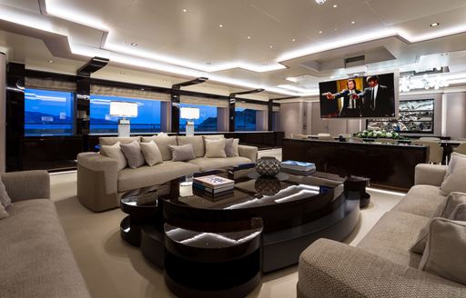 Elegant table and chairs on superyacht O'PARI with TV screen in background