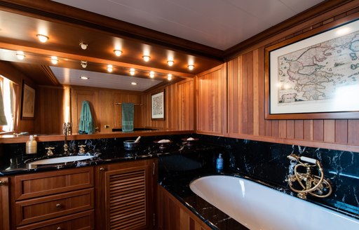 Marble sink and mirror with wooden panelling behind on superyacht 'Bleu De Nimes'