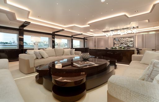 Two cream sofas on superyacht O'PARI with large wooden table in between them