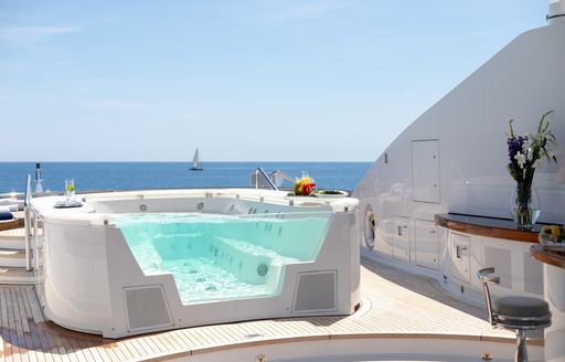 An on-deck Jacuzzi surorunded by views of the sea onboard charter yacht TREEHOUSE