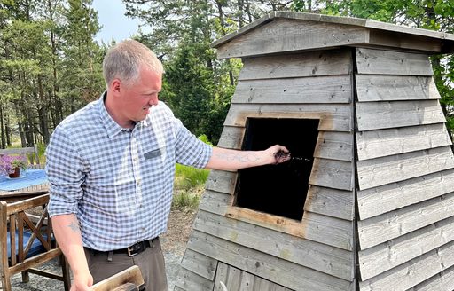 A man tends to a traditional elder wood smoker in Finland