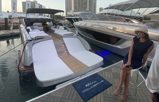 a spokeswoman for a charter brokerage sitting behin the tender of a luxury superyacht in the 2020 miami yacht show