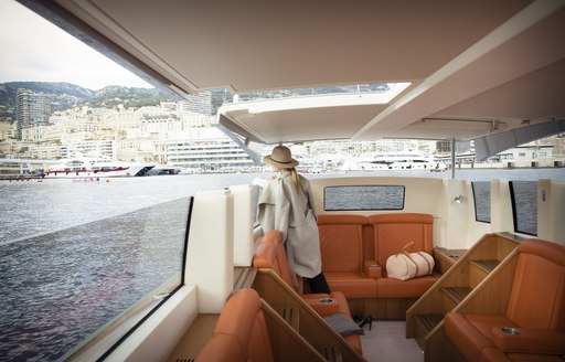 Charter guest on superyacht looks out over Monaco from on board limo tender