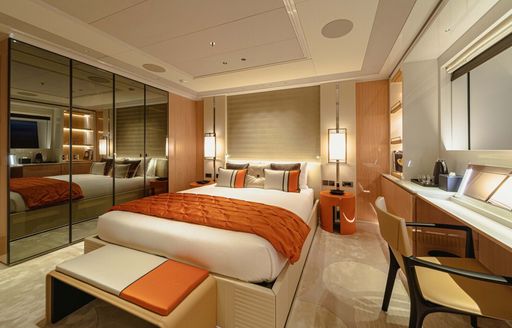 Guest cabin onboard Charter yacht PROJECT X, central berth facing forward with large mirrors to port and a desk to starboard