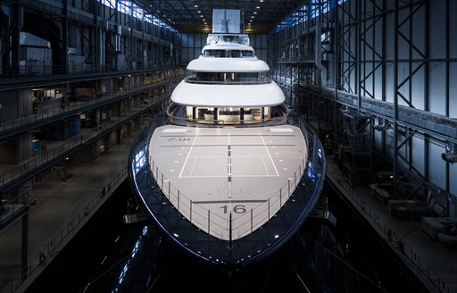Frontal view looking directly at the bow of Feadship Project 821 in a construction shed 