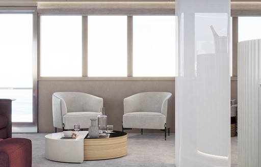 Two white armchairs in front of large windows onboard charter yacht REPOSADO