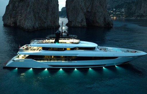 Charter yacht TOY at anchor by large rock formations