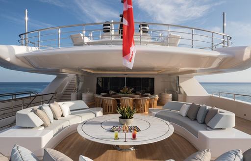 Comfortable seating and table on aft deck of superyacht O'PARI