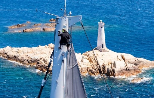 Sailor on mast of yacht during Loro piano superyacht regatta