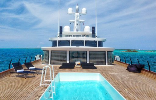 Overview of a swimming pool and sun loungers onboard charter yacht AIR