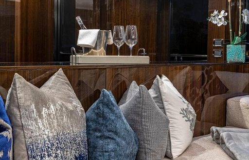 Close up of cushions with Champagne and glasses behind on superyacht OCULUS