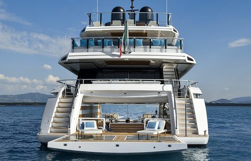 Aft view of boat charter SANCTUARY at sea with sun loungers on the swim platform
