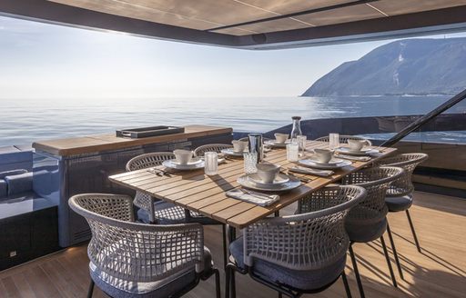 Covered dining area with table and chairs on motor yacht HAZE
